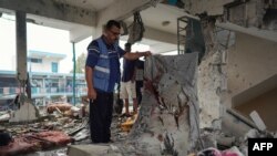 Član Misije Ujedinjenih nacija provjerava školu UN-a u kojoj su smješteni raseljeni ljudi koja je pogođena tokom izraelskog bombardiranja u Nuseiratu, u središnjem pojasu Gaze, 6. juna 2024.
