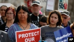 美国科罗拉多州参议院民主党籍参议员艾琳·阿吉拉尔（左）与平价医疗法案支持者一起参加抗议活动，反对废除这一法案。