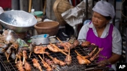 A street vendor cooks food on a street in central Bangkok, Thailand, Friday, April 22, 2016. In Bangkok, street food remains the heart and soul of local cuisine, sold day and night from carts and makeshift stands. (AP Photo/Mark Baker)