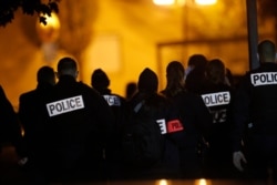 French police officers gather outside a high school after a history teacher who opened a discussion with students on caricatures of Islam's Prophet Muhammad was beheaded, in Conflans-Saint-Honorine, north of Paris, Oct. 16, 2020.