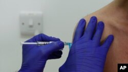 In this Wednesday, Oct. 7, 2020, file photo, a Phase 3 Novavax coronavirus vaccine trial volunteer is given an injection at St George's University hospital in London. (AP Photo/Alastair Grant, File)
