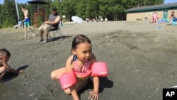 Warga di Anchorage, Alaska mendinginkan diri di danau akibat gelombang panas yang melanda hari Jumat (5/7).