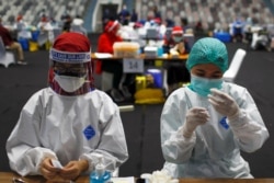 Petugas kesehatan menyiapkan vaksin Sinovac untuk COVID-19 saat vaksinasi massal untuk tenaga medis Indonesia, di Stadion Istora Senayan, Jakarta, 4 Februari 2021. (Foto: REUTERS/Willy Kurniawan)