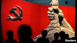 资料照：北京军事博物馆展示的中共党旗与一只握枪的手的雕塑 (路透社 2010年8月13日)
