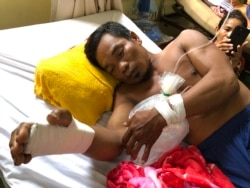 Boeun Bol, 43, with a broken right wrist and bruises on his back, rests on a hospital bed in Phnom Penh, Cambodia, May 11, 2020. (Sun Narin/VOA Khmer)