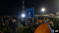 FILE - Migrants and refugees gather at a border crossing between Serbia and Hungary in Kelebija, Serbia, Feb. 6, 2020. 
