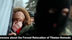 FILE - A woman cries as she waits for humanitarian aid as a Ukrainian serviceman stands nearby in Debaltseve, eastern Ukraine, Feb. 6, 2015. 