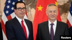 China's Vice Premier Liu He stands next to U.S. Treasury Secretary Steven Mnuchin as they pose for a group photo at Diaoyutai State Guesthouse in Beijing, March 29, 2019.