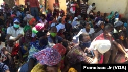 Des personnes déplacées munies de bons alimentaires du PAM attendent une distribution alimentaire à Pemba au Mozambique. le 5 avril 2021.