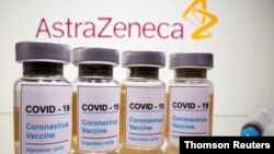FILE PHOTO: Vials and medical syringe are seen in front of AstraZeneca logo in this illustration
