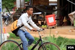 កុមារា ឈឿម សុខុច អាយុ​១៤ឆ្នាំ ជិះ​កង់​មក​ពីសាលារៀន ដែលស្ថិត​នៅ​ក្បែរ​ផ្ទះ​ ក្នុង​ឃុំ​ក្របីរៀល ខេត្ត​សៀមរាប កាល​ពីថ្ងៃ​ទី១៣ ខែកក្កដា ឆ្នាំ២០១៧។ (ស៊ុន ណារិន/VOA)