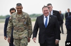 U.S. Secretary of State Mike Pompeo, right, walks with U.S. General Vincent K. Brooks, left, commander of United States Forces Korea, upon his arrival at Osan Air Base in Pyeongtaek, June 13, 2018.