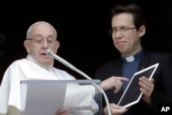 El papa Francisco apunta a una tableta mientras anuncia su perfil en Click to Pray, la app oficial de la Red Mundial de Oración del Papa, durante el Angelus, la oración del mediodía que recita desde la ventana de su estudio que mira hacia la Plaza de San Pedro, en El Vaticano.