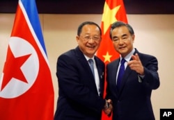 N. Korean Foreign Minister Ri Yong Ho, left, is greeted by his Chinese counterpart Wang Yi prior to their bilateral meeting on the sidelines of the 50th ASEAN Foreign Ministers' Meeting and its Dialogue Partners, Aug. 6, 2017.