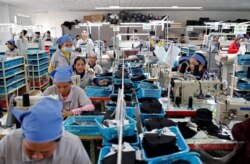 រូបឯកសារ៖ កម្មករ​កំពុង​ដេរ​ស្បែក​ជើង​ក្នុង​រោងចក្រ​ស្បែក​ជើង​មួយ​របស់​ក្រុមហ៊ុន​តៃវ៉ាន់​ ក្នុង​ខេត្ត​កំពង់ស្ពឺ ថ្ងៃ​ទី៤ ខែកក្កដា ឆ្នាំ​២០១៨។