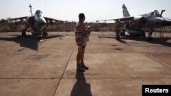 A French soldier stands between two Mirage F1 fighter jets at the Malian army air base in Bamako January 14, 2013.