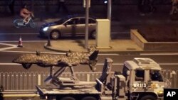 រូប​ឯកសារ៖ រថយន្ត​យោធា​ចិន​មួយ​ដឹក​អ្វី​ម្យ៉ាង​ដែល​មើល​ទៅ​ដូច​ជា​ដ្រូន កាត់​តាម​មហាវិថី Jianguomenwai នៅ​ក្នុង​ក្រុង​ប៉េកាំង កាលពី​ថ្ងៃទី២១ ខែកញ្ញា ឆ្នាំ២០១៩។