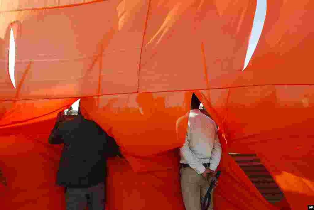 Security personnel look through an opening during an election rally addressed by Uttar Pradesh Chief Minister Yogi Adityanath and Indian Prime Minister Narendra Modi ahead of state elections in Kasganj, India.