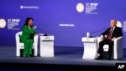 Президент Росії Володимир Путін під час міжнародного економічного форуму в Санкт-Петербурзі, Росія, говорить з Маргаритою Симоньян, керівницею російського телеканалу RT. 17 червня 2022 року. (Олександр Рюмін/ ТАСС/AP)