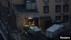 Supermarket staffers wait for delivery trucks during an early morning air-raid alert, amid Russia's attacks on Ukraine, in Kyiv, Feb. 11, 2025.