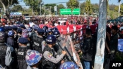 Police block protesters as they gather near a statue of General Aung San during a demonstration in Loikaw, Myanmar, Feb. 12, 2019.