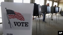 FILE - Voters cast ballots in an Illinois primary in Hinsdale, Ill., March 18, 2014. In past elections, young adults have been on the lower end in terms of voter turnout, and expectations for the coming election appear uncertain. 