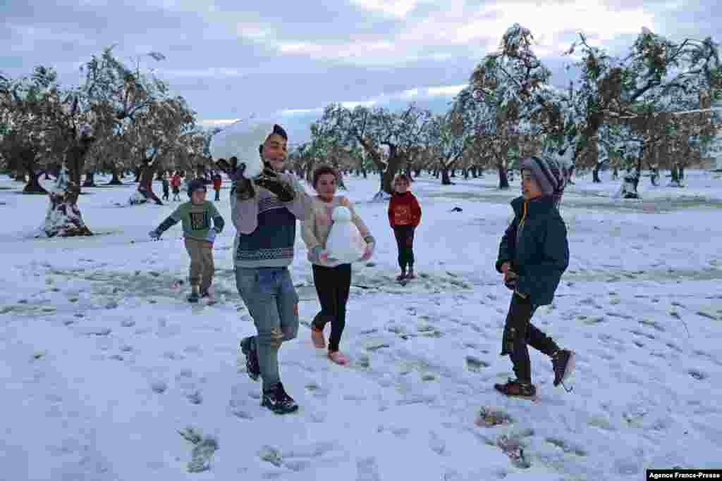 Children play in the snow at a camp for internally displaced Syrians near Afrin city in the rebel-controlled northern countryside of Syria's Aleppo province.