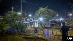 ARCHIVO - Una persona observa desde detrás de una valla de precaución que rodea el área donde se derrumbó un escenario durante un mitin de campaña del candidato presidencial mexicano Jorge Álvarez Maynez en San Pedro Garza García, Nuevo León, México, el 22 de mayo de 2024.