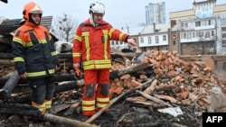 Ukrainian rescuers access at the debris for clearing at a residential building, partially destroyed after a missile strike on Kharkiv on Jan. 30, 2023.