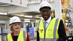 英国首相利兹·特拉斯（Liz Truss）10月14日将她的财政大臣夸西·克沃滕（Kwasi Kwarteng）革职。图为特拉斯和克沃滕2022年9月23日在一家工厂参观。-美联社资料照。