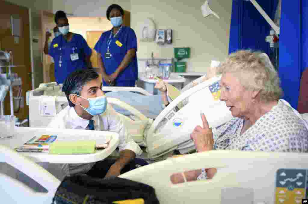 Britain's Prime Minister Rishi Sunak, left, speaks with patient Catherine Poole as he visits Croydon University Hospital in South London.