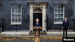 British Prime Minister Liz Truss announces her resignation, as her husband Hugh O'Leary stands nearby, outside Number 10 Downing Street, London, Britain October 20, 2022. (REUTERS/Henry Nicholls)