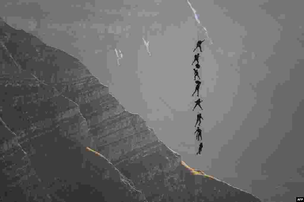 Soldiers of the Swiss Special Forces command perfotm suspended from an helicopter, during the annual live fire event over the Axalp in the Bernese Oberland, Switzerland.