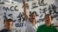 FILE - Chinese laborers Jingbao Zhao, left, Xiaoli Wang, center, and Yongbo Sun protest in front of the Imperial Pacific Casino in Saipan, the Northern Mariana Islands, July 26, 2017. 