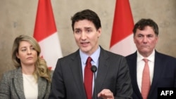 O primeiro-ministro do Canadá, Justin Trudeau, discursa, ladeado pela ministra dos Negócios Estrangeiros, Melanie Joly (E), e pelo ministro das Finanças e Assuntos Intergovernamentais, Dominic LeBlanc.