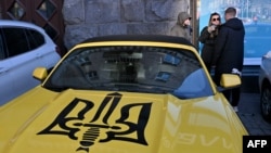 Національна стратегія надходжень має забезпечити потреби бюджету в час невизначеності щодо великих пакетів донорів, кажуть в МВФ. Фото для ілюстрації: машина в Києві оздобена гербом України, грудень 2023 року.