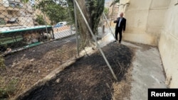 聯合國近東救濟工程處約旦河西岸事務主任亞當布魯克斯（Adam Bouloukos）向人們展示該機構總部旁被當地以色列居民縱火焚燒後的情景。 （2024年5月10日）