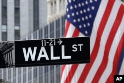 FILE - American flags fly at the New York Stock Exchange on Wall Street, July 6, 2015.