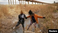 Migranti prelaze rijeku Rio Bravo kako bi se predali i zatražili azil u El Pasu u Teksasu, SAD, kako se vidi iz Ciudad Juareza u Meksiku 1. februara 2021. godine.