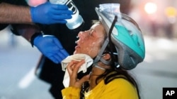 A medic treats Black Lives Matter protester Lacey Wambalaba after exposure to chemical irritants deployed by federal officers at the Mark O. Hatfield United States Courthouse, July 24, 2020, in Portland, Oregon. 