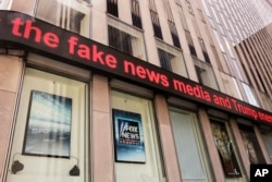 FILE - News headlines scroll above the Fox News studios in the News Corporation headquarters building in New York, Aug. 1, 2017.