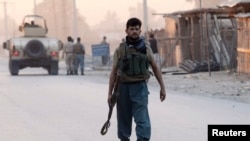 An Afghan policeman arrives at the site of an attack in Jalalabad city, Aug. 30, 2014. 