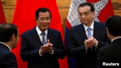 រូបឯកសារ៖ លោក​នាយករដ្ឋមន្ត្រី ហ៊ុន សែន ទះដៃ​ជាមួយ​នឹង​នាយករដ្ឋមន្ត្រី​ចិន លោក Li Keqiang ក្នុង​អំឡុងពេល​នៃ​ពិធី​ចុះ​ហត្ថលេខា​មួយ​នៅ​ឯ​មហាសាល​ប្រជាជន​ក្នុង​ទីក្រុង​ប៉េកាំង ប្រទេស​ចិន ថ្ងៃ​ទី២២ ខែមករា ឆ្នាំ​២០១៩។