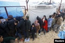 Internally displaced Syrians line up to receive blankets near the Bab al-Salam crossing, across from Turkey's Kilis province, on the outskirts of the northern border town of Azaz, Syria, Feb. 6, 2016.