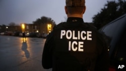 FILE - U.S. Immigration and Customs Enforcement (ICE) agents enter an apartment complex looking for a specific undocumented immigrant convicted of a felony during an early morning operation in Dallas, Texas, March 6, 2015.
