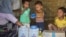 Rohingya children eat from jars with the USAID logo on them, at a refugee camp in Cox's Bazar, Bangladesh, Feb. 11, 2025.
