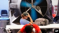 Dua pria tunawisma mendinginkan diri di Justa Center, layanan khusus bagi warga tunawisma, saat suhu mencapai 110 derajat (di atas 43 Celsius) di Phoenix, Arizona (foto: dok).