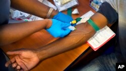 FILE - A clinical trial patient receives a dose of AstraZeneca test vaccine at the University of Witwatersrand facility in Soweto, South Africa, Nov. 30, 2020. 
