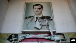 A torn poster shows ousted Syrian President Bashar al-Assad at the entrance of a detention center in Damascus, Syria, Dec. 14, 2024.