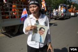 A woman holds Kem Ley portrait as thousands of Cambodians march at the late Kem Ley's funeral procession heading to his hometown in Tram Kak district, Takeo province, on Sunday morning, July 24, 2016. (Leng Len/VOA Khmer)